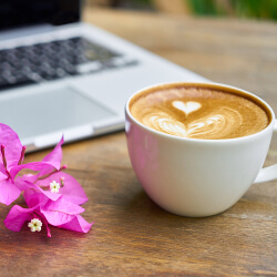 Cup of latte with a computer