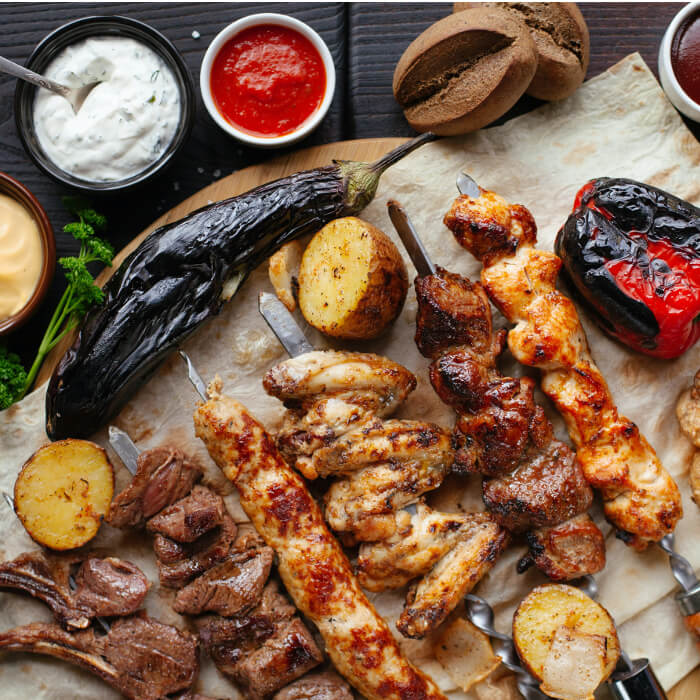 Shish kabobs on a platter with sauces