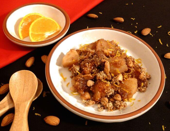 Apple Crisp on a plate with toasted almonds and sprinkled with orange zest