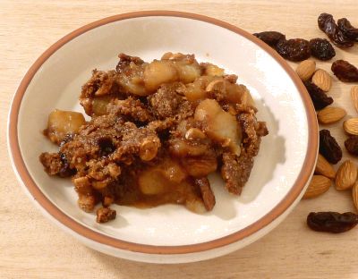 Apple Crisp on a plate with toasted almonds using panela sugar and raisins