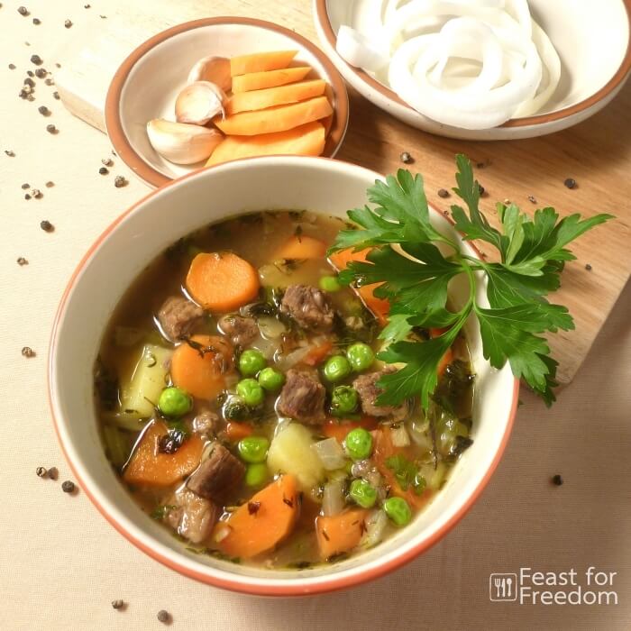 Beef soup in a bowl garnished with parsley