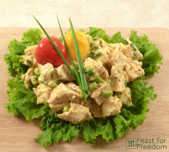 Chicken salad on a bed of lettuce on a cutting board
