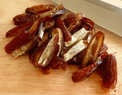 Dates cut in half on a cutting board