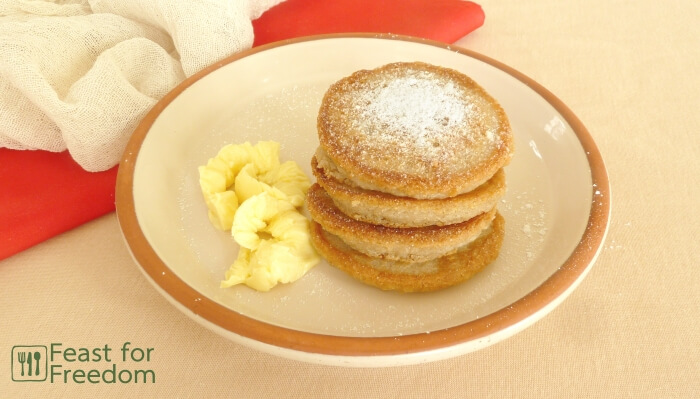 Stack of gluten free pancakes with butter and powdered sugar