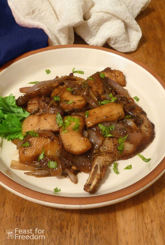 Maple glazed pork chops on a plate garnished with a celery sprig