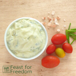 Ranch salad dressing in a bowl next to tomatoes