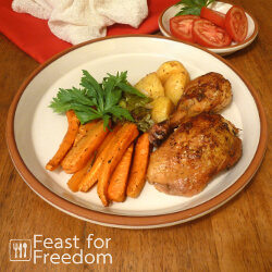 Roast chicken with roasted carrots and potatoes on a plate