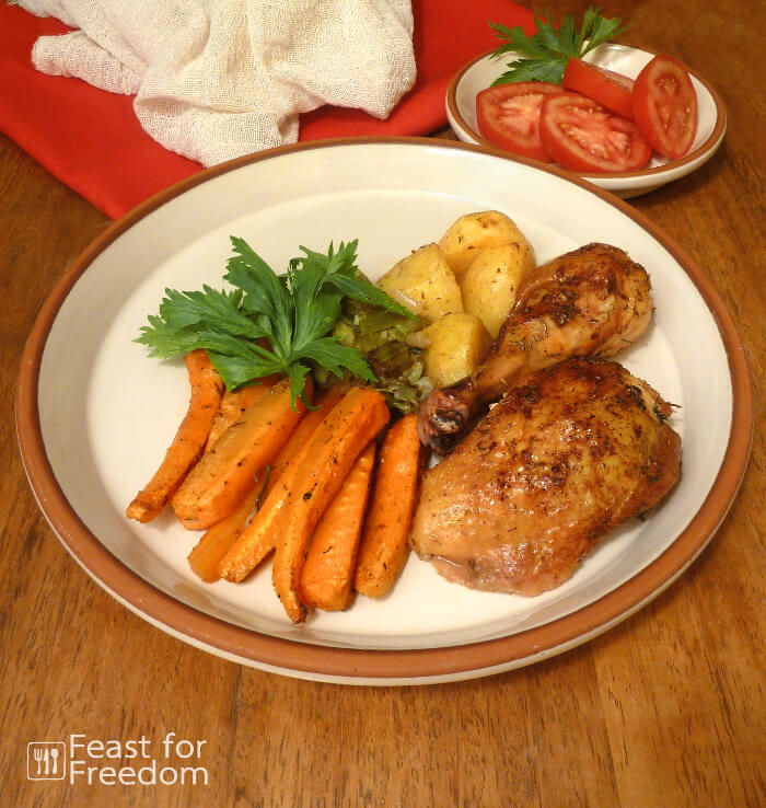 Roast chicken with roasted carrots and potatoes on a plate