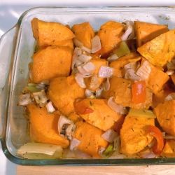 Roasted sweet potatoes with onions and red pepper in a baking dish