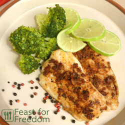 Pan fried fish with a savory spice rub with steamed broccoli and limes